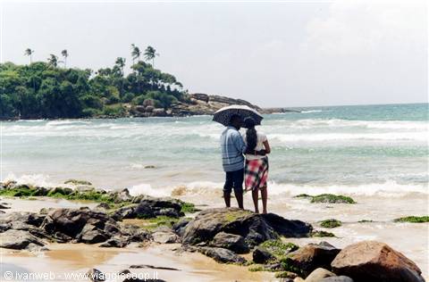 Una coppietta in una romantica passeggiata in spiaggia