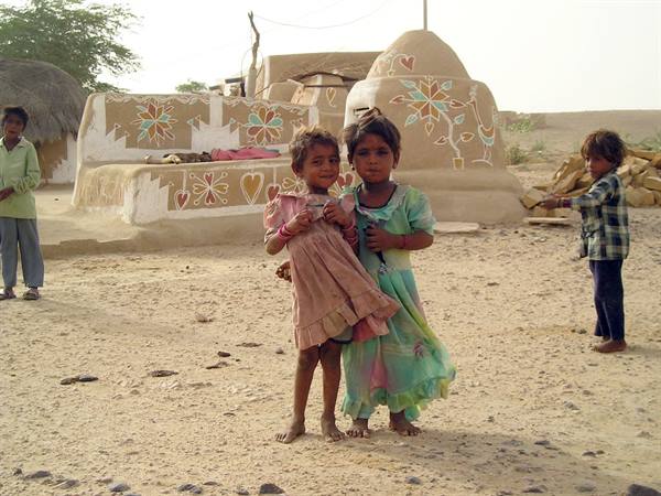 Girls in front of painted mud houses, Rajasthan desert village