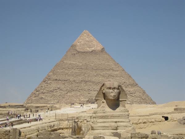 The Great Sphinx before the Cheops pyramid at Giza, tourists walking
