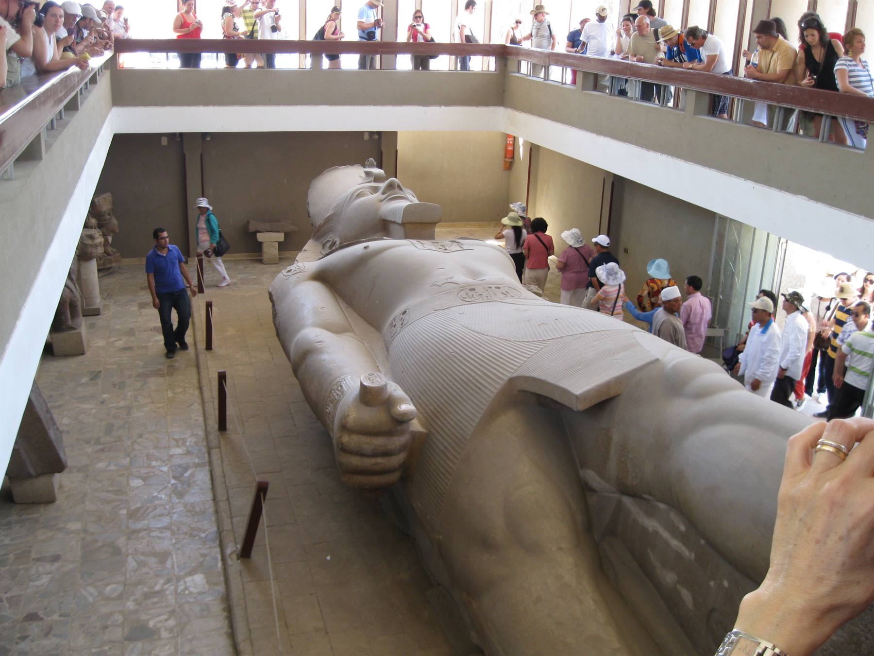 Colossus of Ramesses II lying at Memphis museum, tourists around