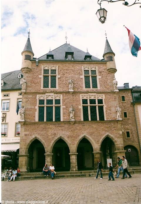 Old stone town hall with arched arcade, statues and turrets, Echternach square