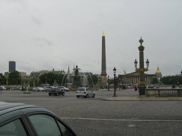Place de la Concorde with the Egyptian obelisk, cars passing, grey sky