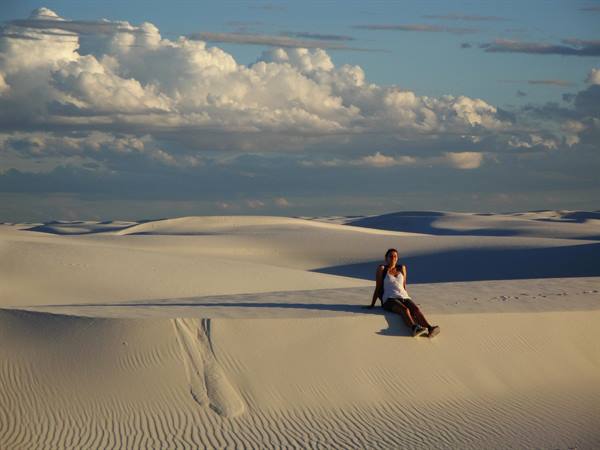 Ragazza seduta su una duna di gesso a White Sands, luce serale