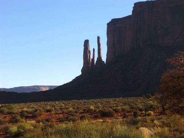 Monument Valley: i Tre Frati in ombra sotto il cielo azzurro