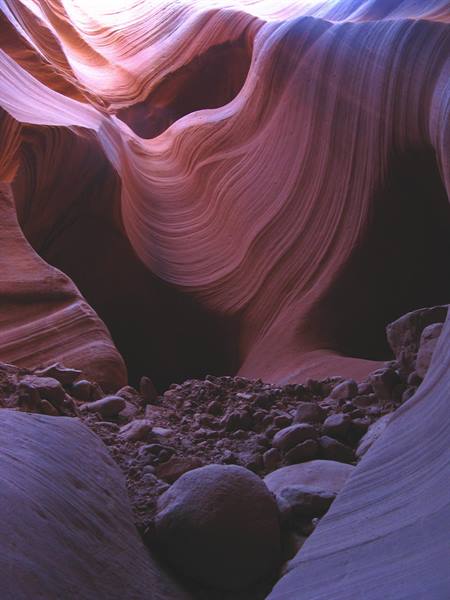 Antelope Canyon, Page: pareti di arenaria ondulate, luce violette sui sassi