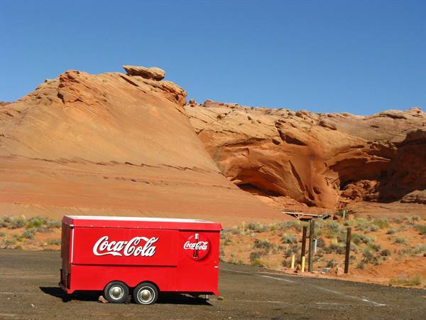Rimorchio rosso Coca-Cola parcheggiato davanti alle rocce rosse di Page