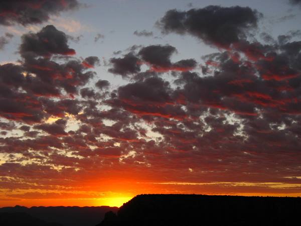 Il sole rosso scompare dietro la mesa in controluce