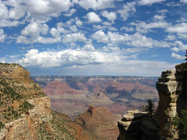 Grand Canyon: pareti rocciose rosse sotto un cielo di nuvole bianche