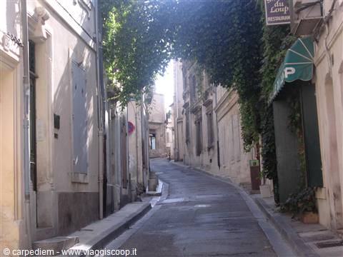 Uphill alley between old buildings with ivy and a restaurant sign