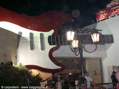 Giant red and white guitar decorates the Hard Rock Cafe entrance at night