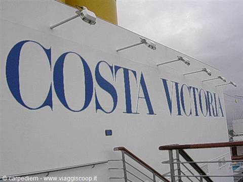Blue Costa Victoria lettering on white ship hull, grey sky