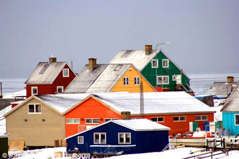 Colorful wooden houses covered in snow under gray Arctic sky