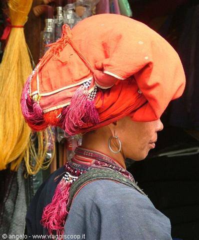 Woman wearing red turban and silver earring at Sa Pa market