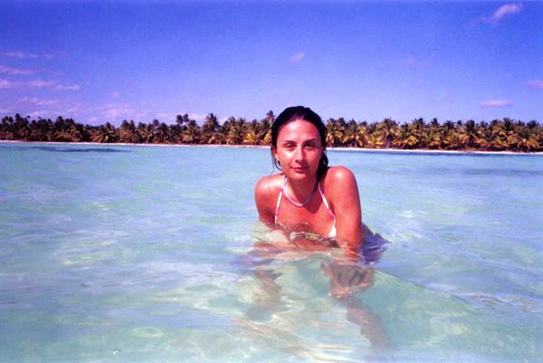 Woman in turquoise water at Saona, palms in the background