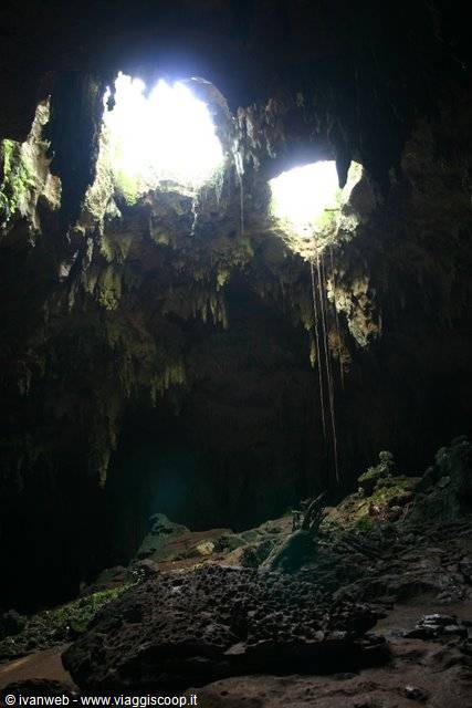 Limestone cave with stalactites and two light openings above
