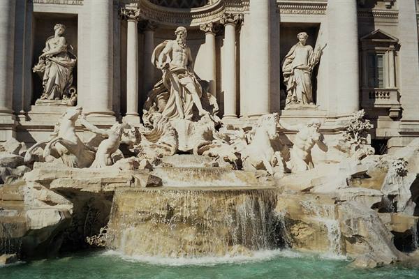 Marble statues of the Trevi Fountain with Oceanus, water flowing among rocks