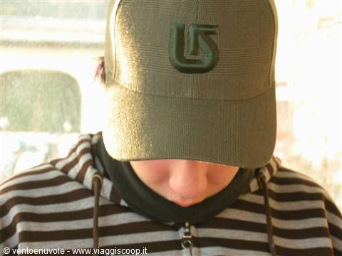 Boy wearing green Burton cap and brown striped hoodie, daylight