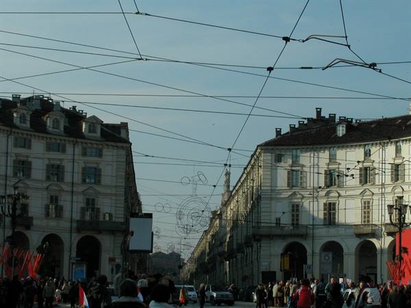 Tram wires crisscross over Turin's Piazza Vittorio, Mole Antonelliana in the distance