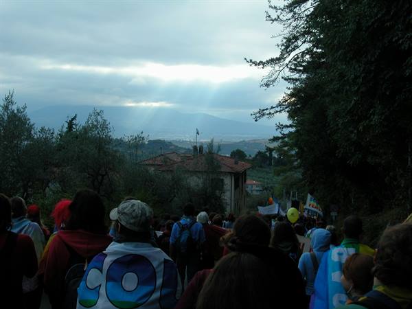 Crowd of people with flags walking down the tree-lined road