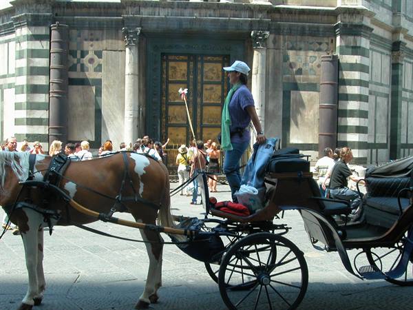 Horse-drawn carriage in front of the Florence Baptistery bronze doors