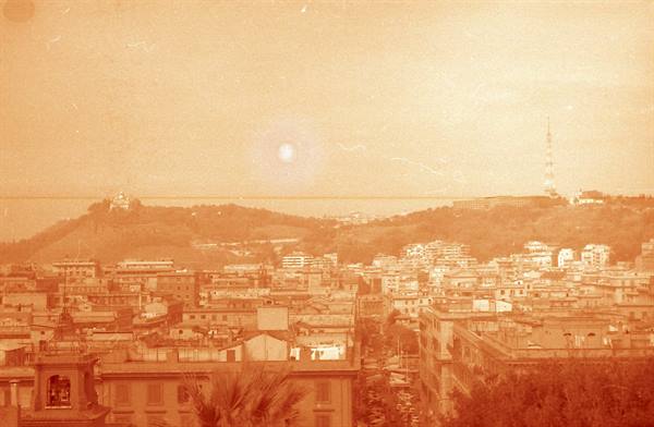 Naples: city rooftops, hilltop antenna tower, sea and waterfront in background