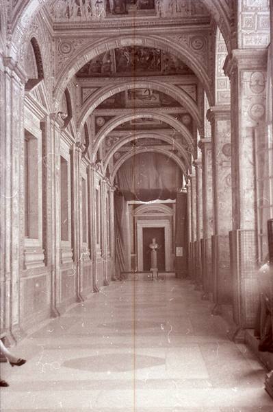 Ornate corridor with decorated arches, frescoes, marble and soft light
