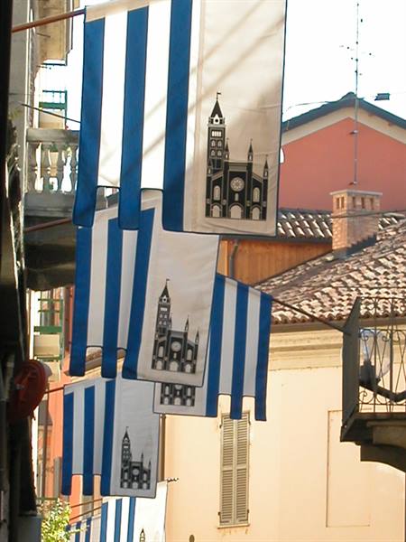 Blue and white banners with a cathedral design hung between rooftops