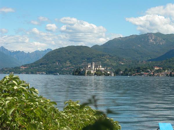 Isola San Giulio on Lake Orta, green mountains and foreground leaves