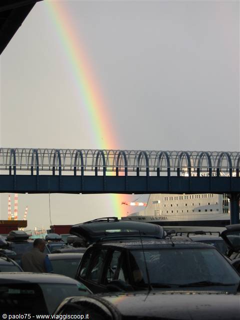 Rainbow over the La Supera ferry at the port, cars queuing to board