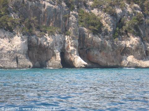 Limestone cliffs with caves above the turquoise sea of the Gulf of Orosei