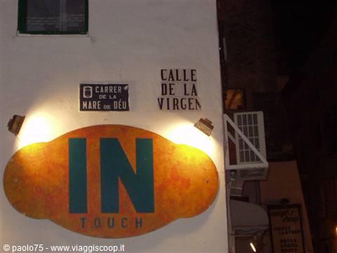 Lit IN Touch sign beneath street name plaques in Ibiza
