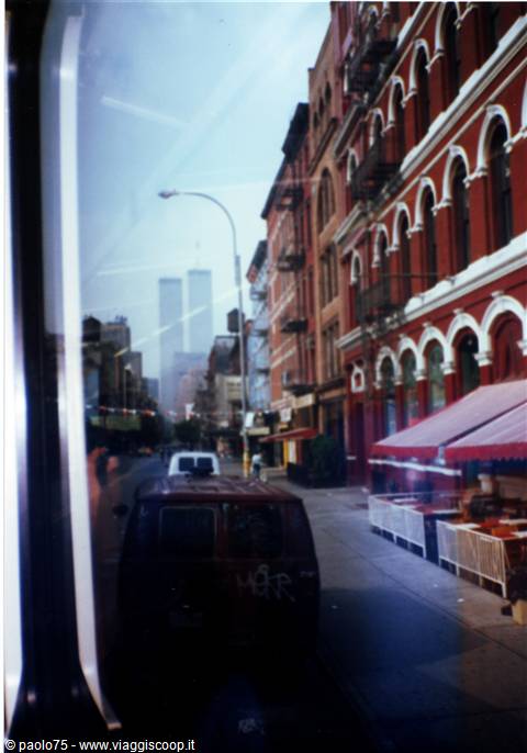 New York street with van and red brick buildings, Twin Towers in background