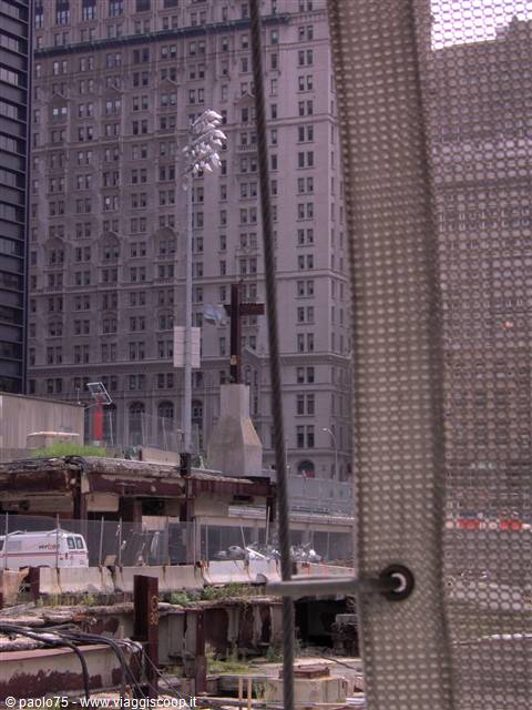 The steel cross at Ground Zero amid rubble and Manhattan buildings