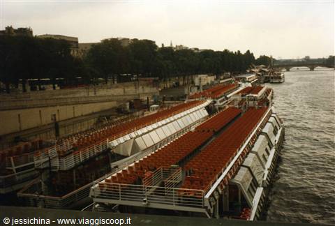 Sightseeing boats with red seats moored along the Seine in Paris