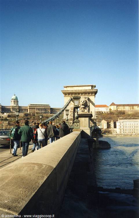 Tourists walk on the Chain Bridge with Buda Castle in the background