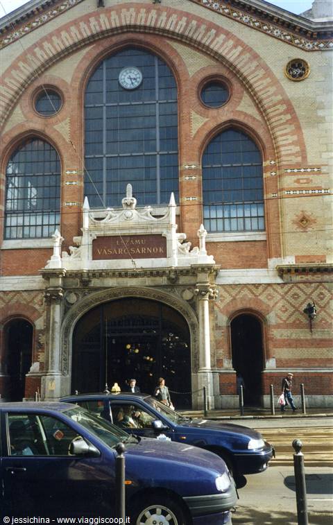 Brick facade of Budapest's Nagycsarnok central market hall, cars parked by entrance