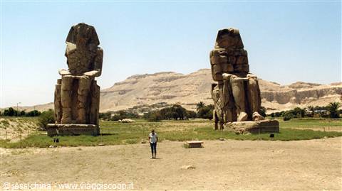 Tourist walks in front of the Colossi of Memnon at Luxor, bright light