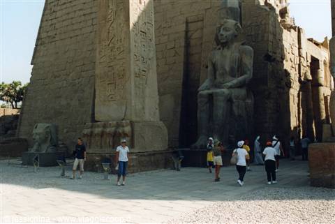 Tourists walking past the colossal seated statue of Ramses II, Luxor