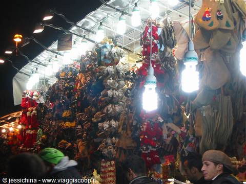 Night market stall with stuffed toys hanging under bright light bulbs
