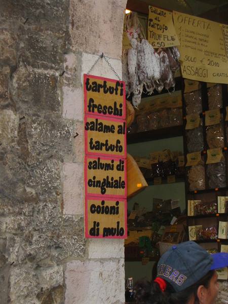 Handmade sign advertising fresh truffles and salami outside a shop
