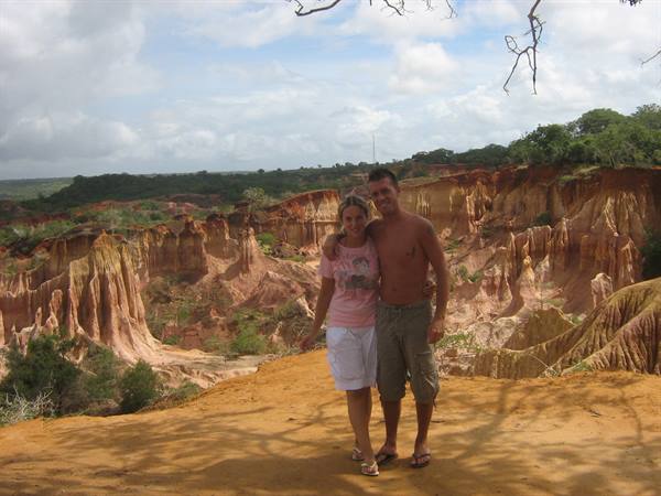 Couple standing at the edge of Marafa Canyon, eroded red earth