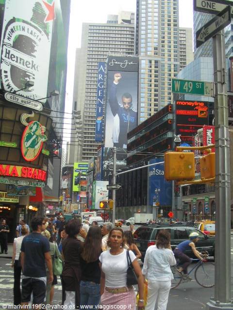 Crowd and billboards in Times Square, New York, among skyscrapers and traffic