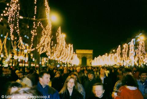 Crowd on the Champs-Élysées under festive lights, Arc de Triomphe in background