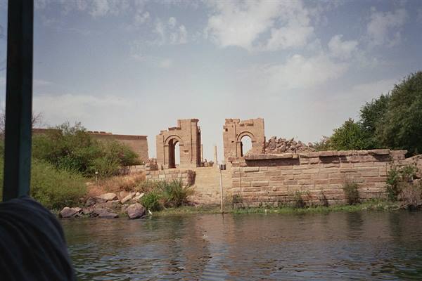 Sandstone arches of Philae island seen from a boat on the Nile