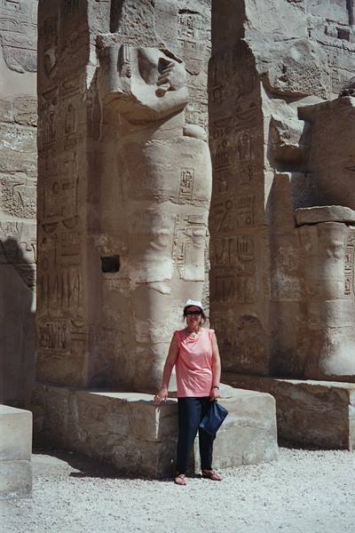 Tourist beside the giant carved columns of Karnak temple