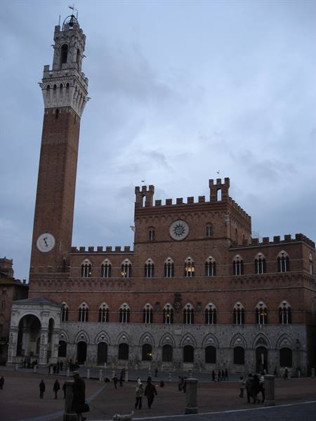 Palazzo Pubblico and Torre del Mangia under grey sky, people walking below