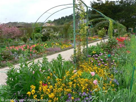 Green metal arches in Monet's garden at Giverny, colorful flowers blooming