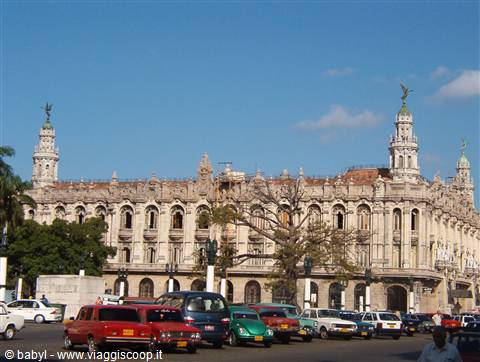 Classic cars in front of the Gran Teatro de La Habana under blue sky