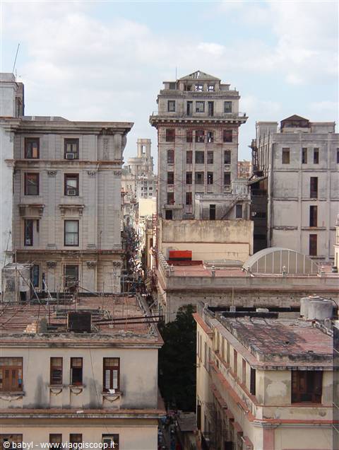 Weathered old high-rise buildings above Havana rooftops, daylight
