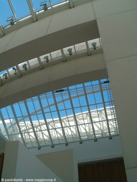 Glass ceiling of a modern building, white beams against the blue sky